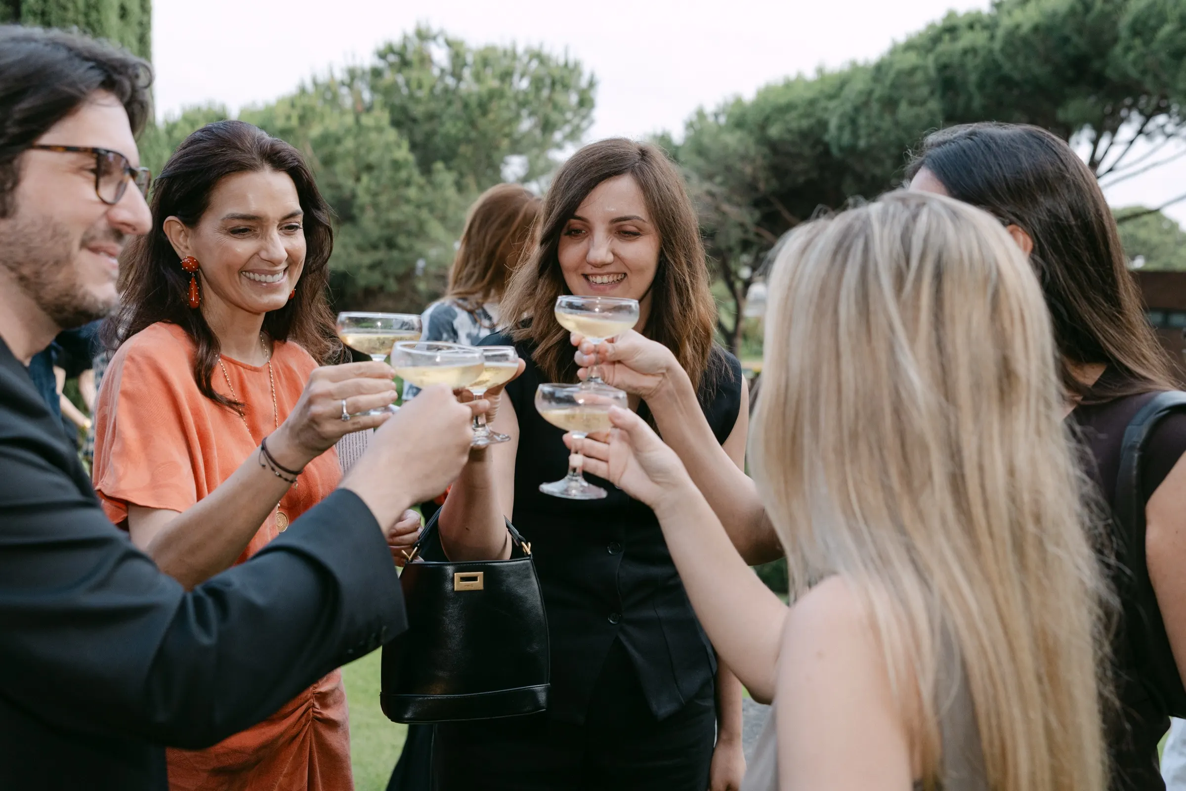 Invitadas brindando con copas de cava en el jardín del evento AD100 de AD España y Sklum. Fotografía de Noomadik.