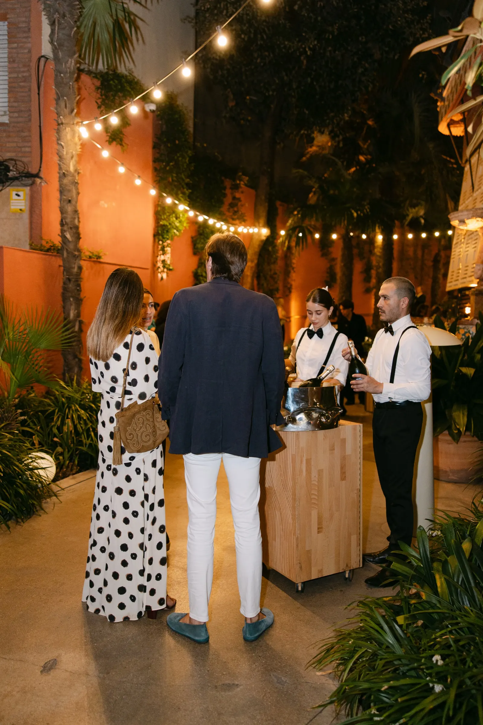 Camareros sirviendo bebidas a invitados en la barra del jardín de la Casa Vicens en el AD100. Fotografía de Noomadik.