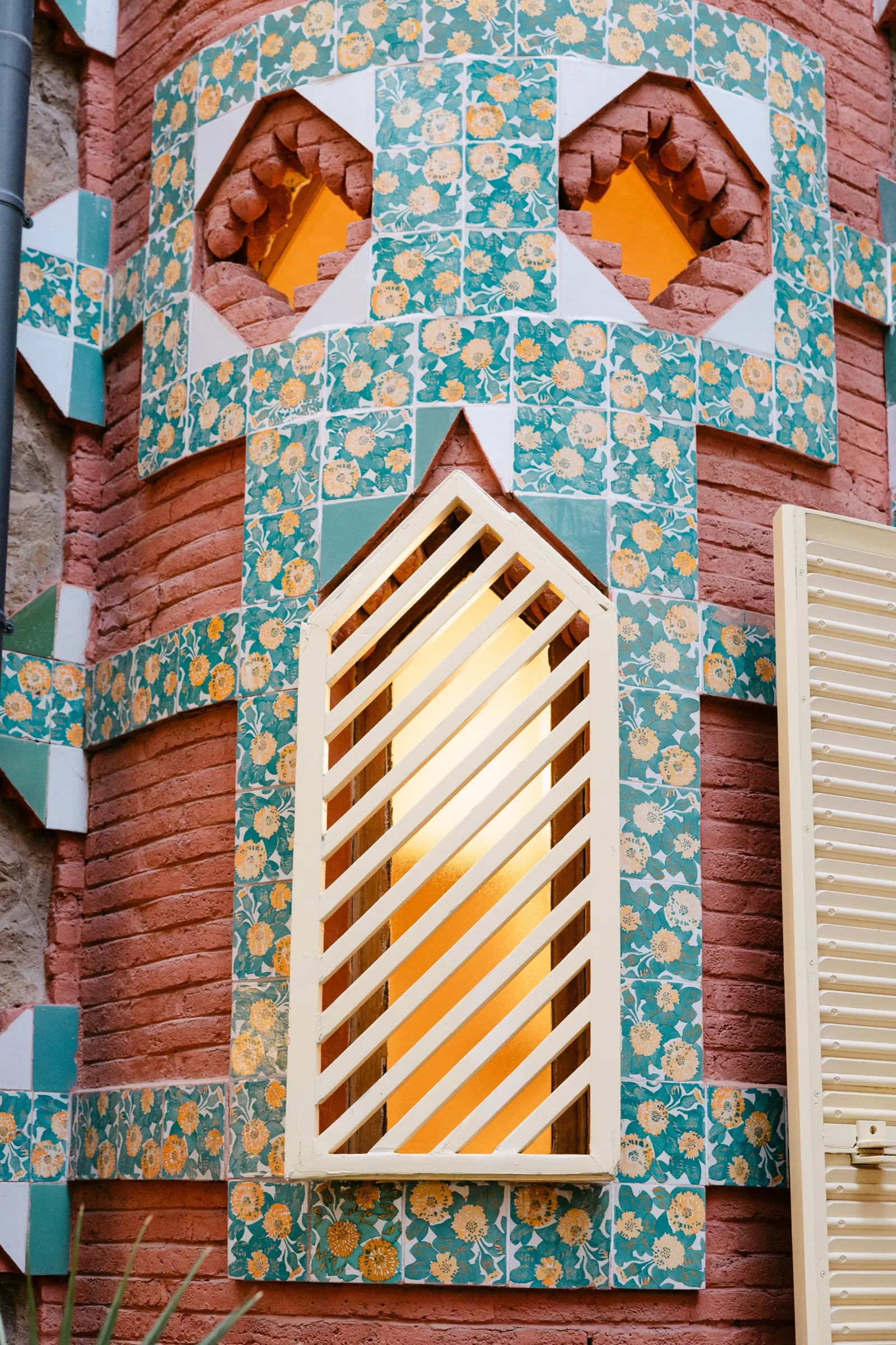 Detalle de azulejos y celosía de una ventana de la fachada de la Casa Vicens de Gaudí. Fotografía de Noomadik.
