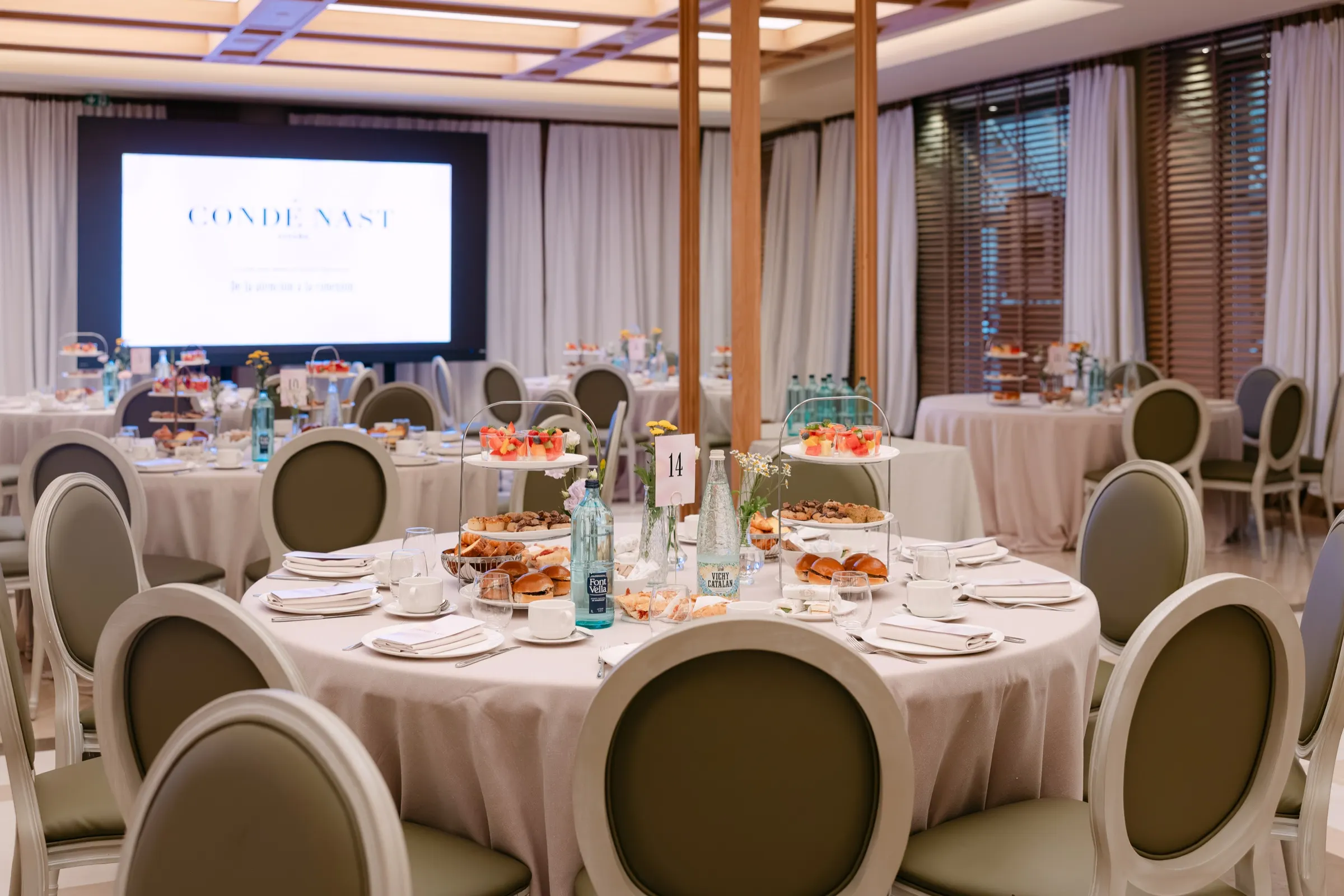 Salón del Hotel Majestic con mesas redondas preparadas para el brunch del Condé Nast Summit. Fotografía de Noomadik.