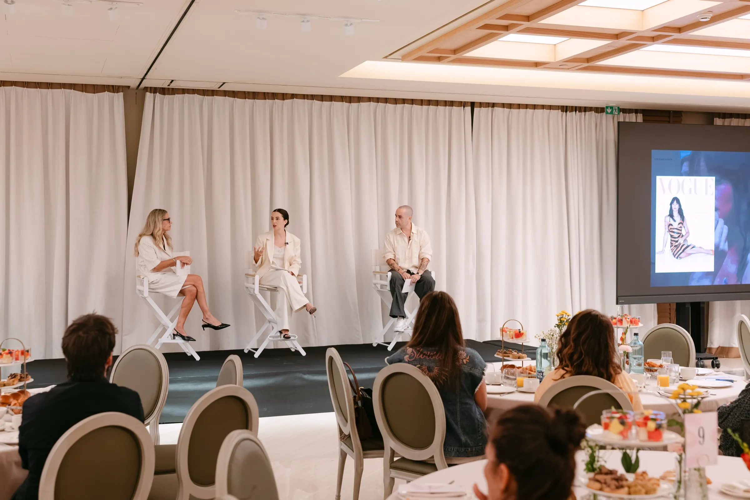 Mesa redonda con tres ponentes en el escenario del Condé Nast Summit en el Hotel Majestic. Fotografía de Noomadik.