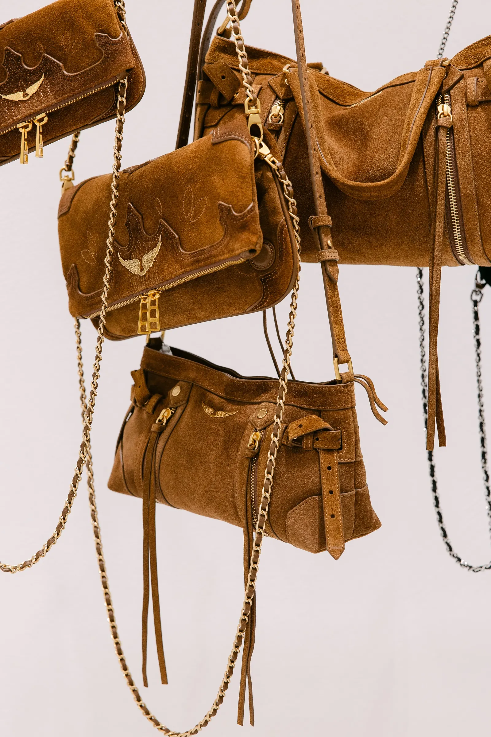 Bolsos de ante colgados con cadenas doradas en la presentación de Zadig & Voltaire en Barcelona. Fotografía de Noomadik.