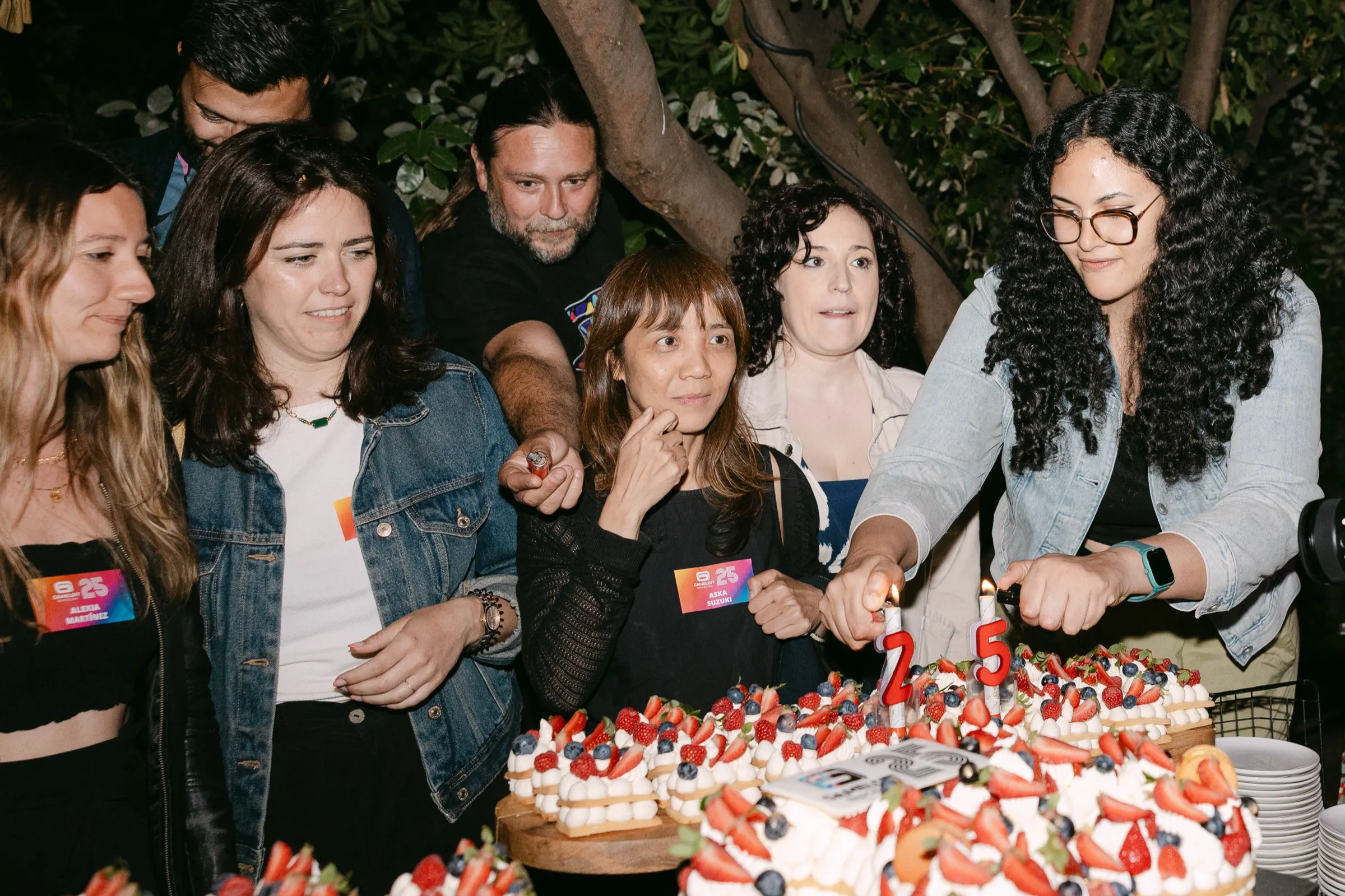 Equipo cortando la tarta en el jardín durante el 25 aniversario de Gameloft Barcelona. Fotografía de Noomadik.