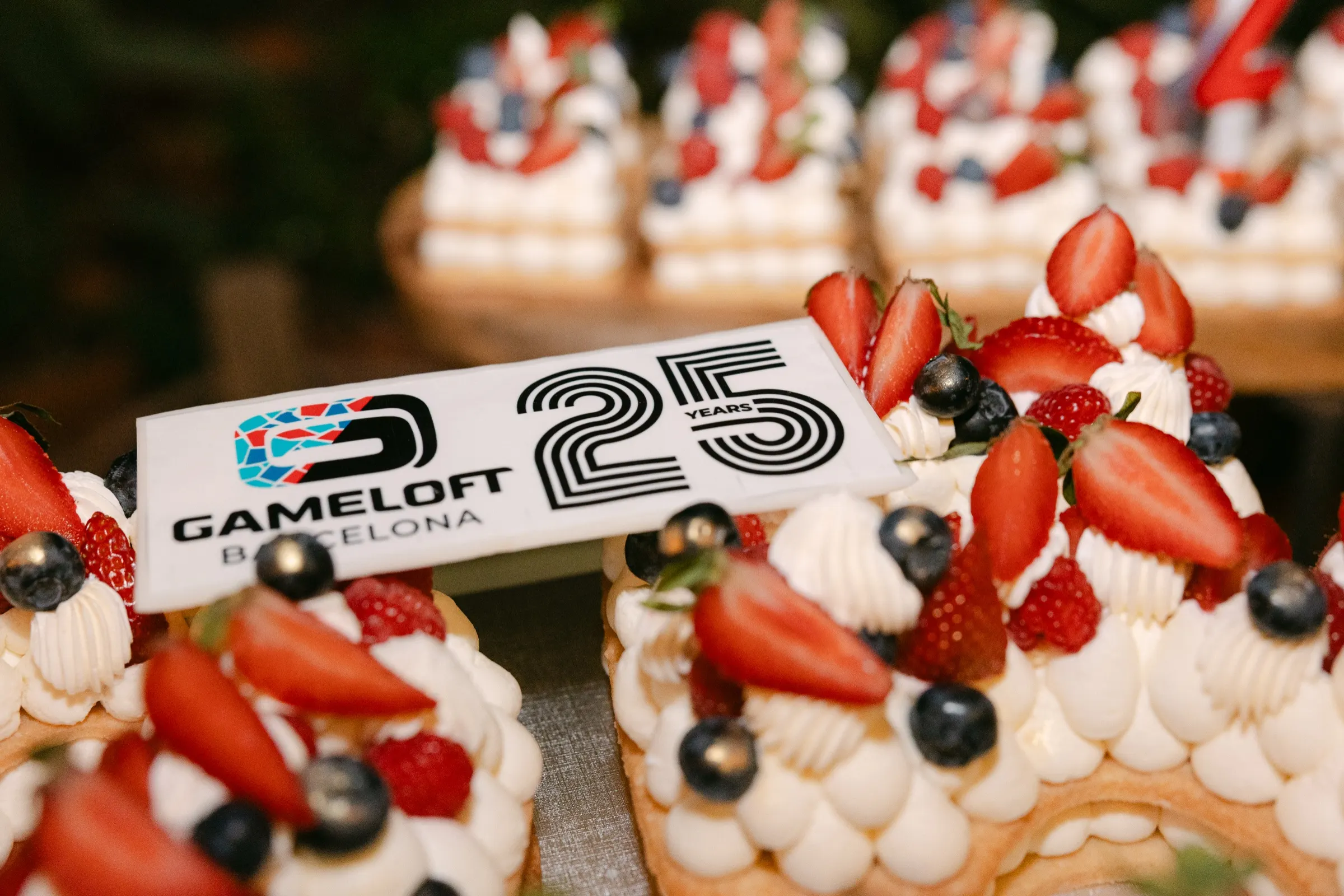 Tartas de nata y frutos rojos con el logo del 25 aniversario de Gameloft Barcelona. Fotografía de Noomadik.