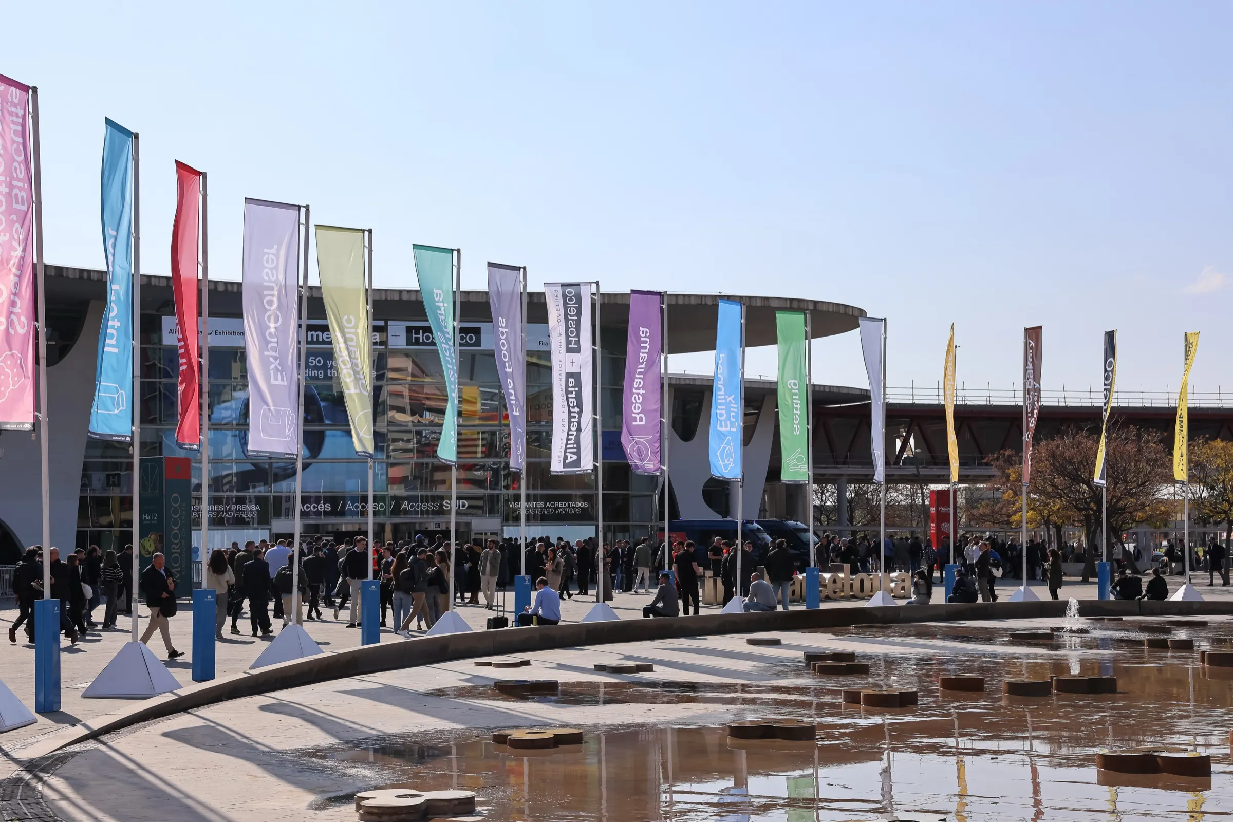 Banderas y visitantes en la entrada de Alimentaria en Fira Barcelona Gran Via. Fotografía de Noomadik.
