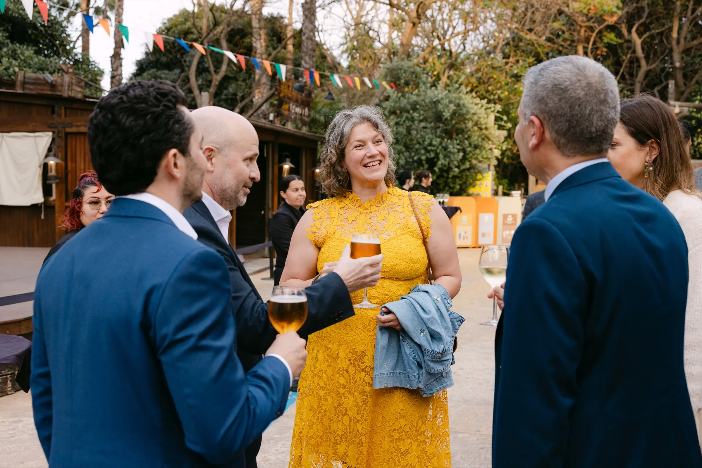 Asistentes conversando con una cerveza en la pausa al aire libre de Merck en PortAventura. Fotografía de Noomadik.