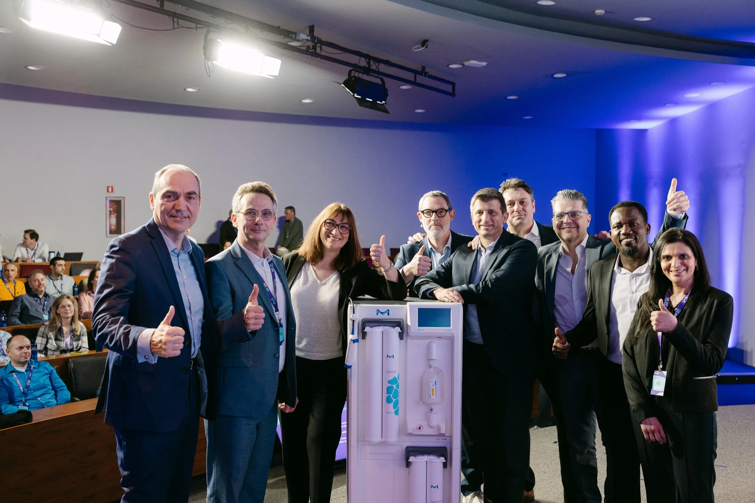 Equipo con los pulgares arriba en la sala plenaria de la reunión de ventas de Merck en PortAventura. Fotografía de Noomadik.