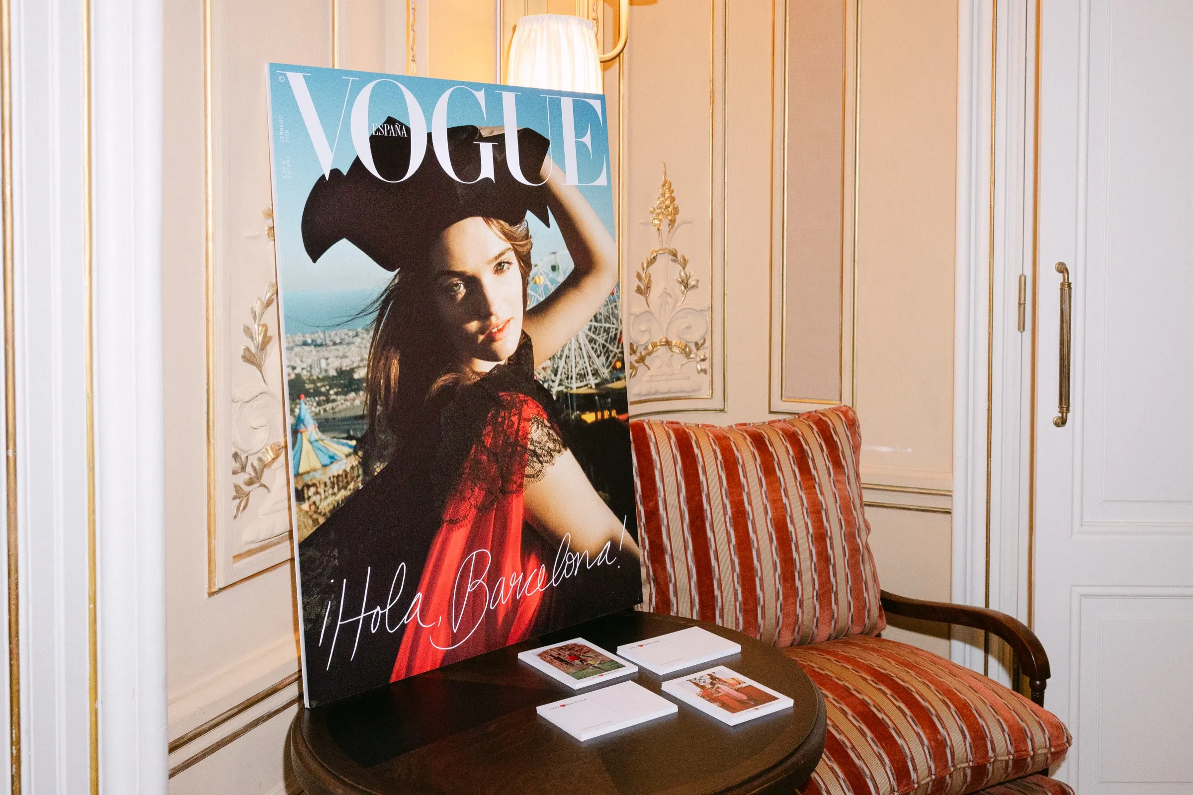 Portada gigante del número «¡Hola, Barcelona!» de Vogue España junto a un sillón tapizado. Fotografía de Noomadik.
