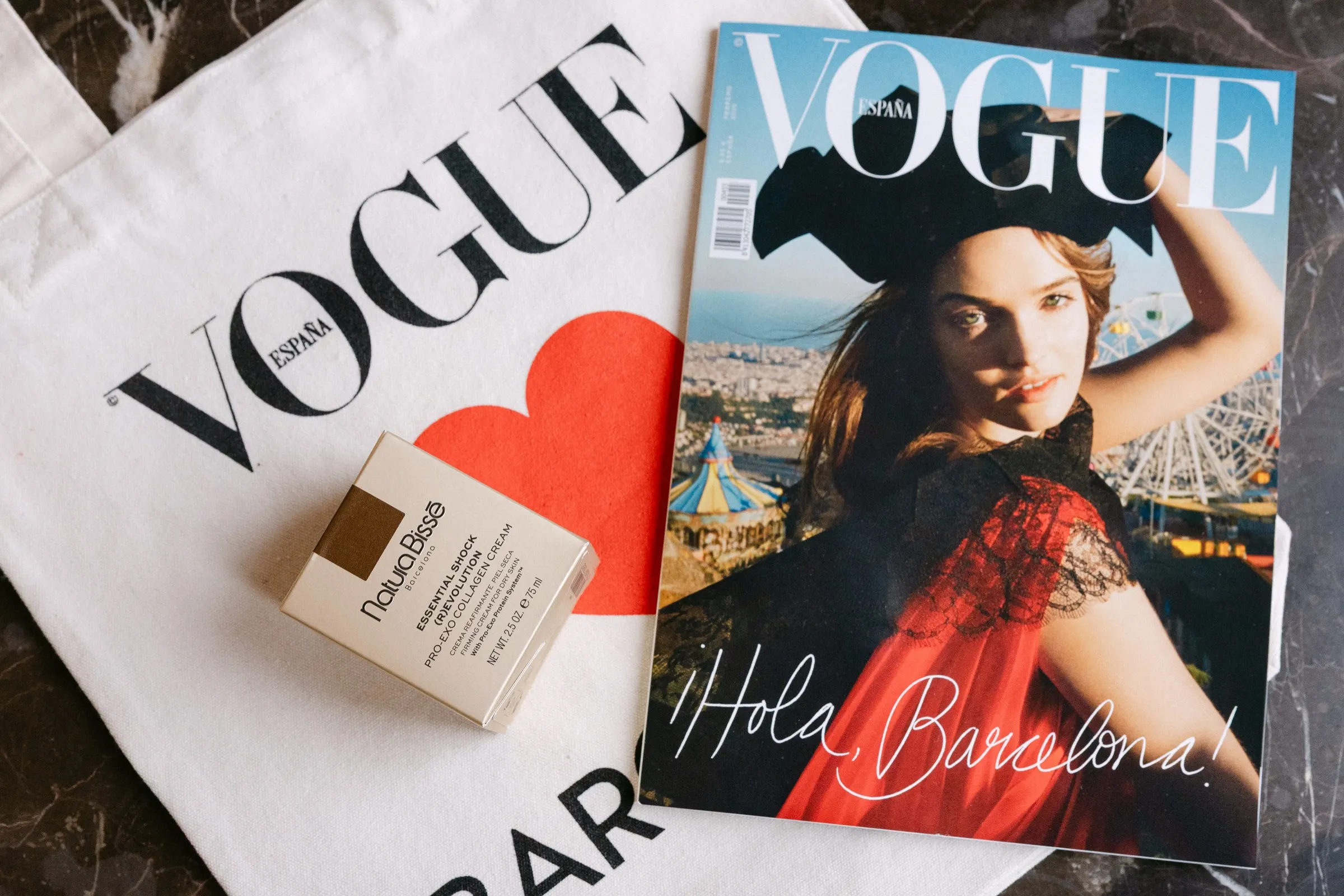 Número «¡Hola, Barcelona!» de Vogue España con bolsa de tela y regalo cosmético. Fotografía de Noomadik.