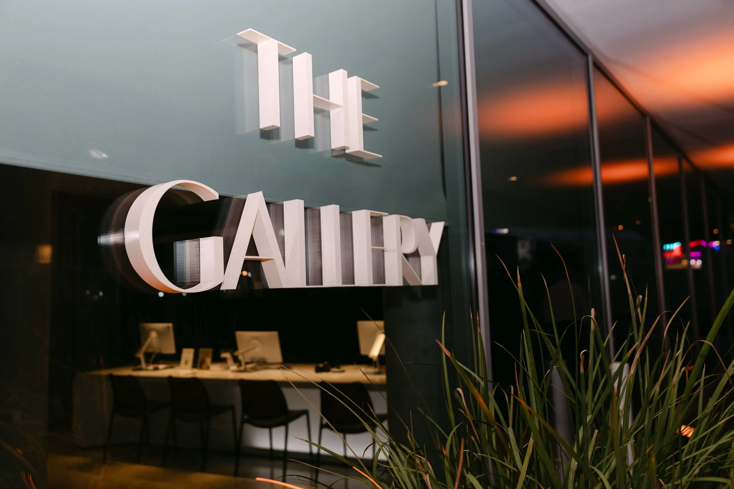 Letras de The Gallery en la fachada acristalada de Marina Port Vell al atardecer, evento de Zeekr. Fotografía de Noomadik.
